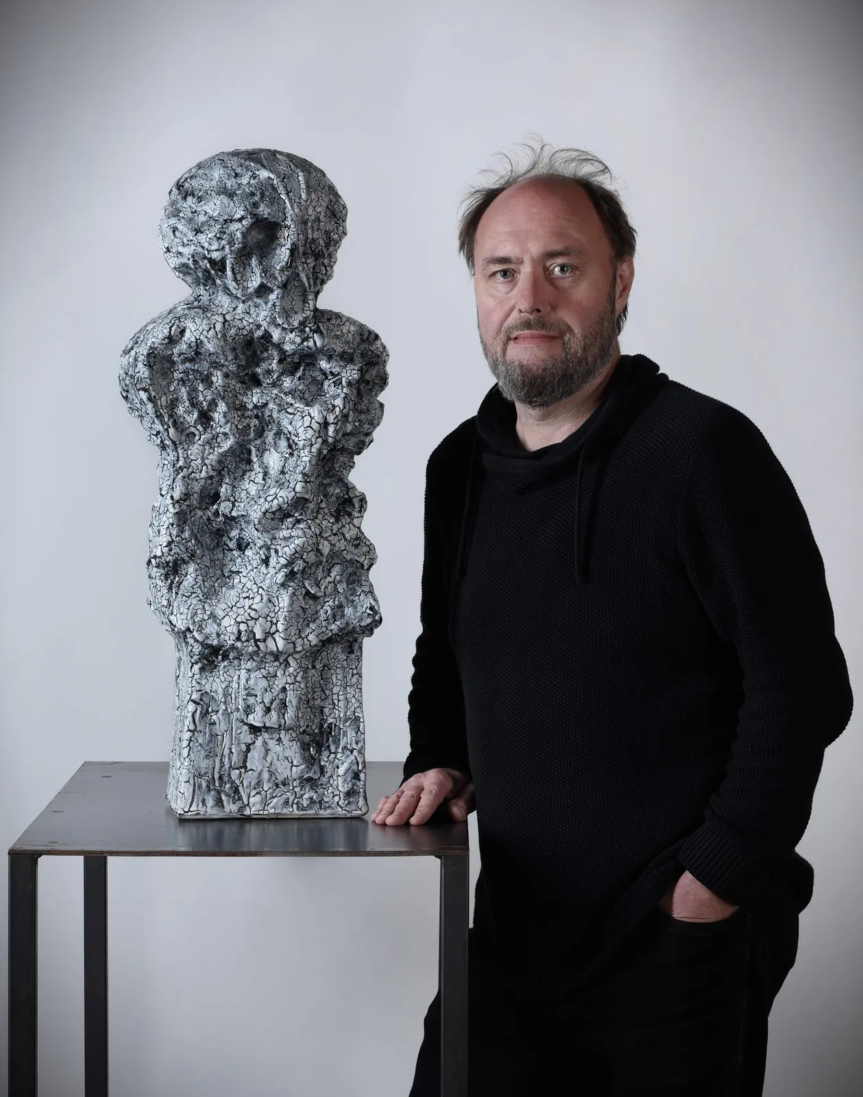 Petr Lada stojí vedle své plastiky s bílou krakelovanou glazurou