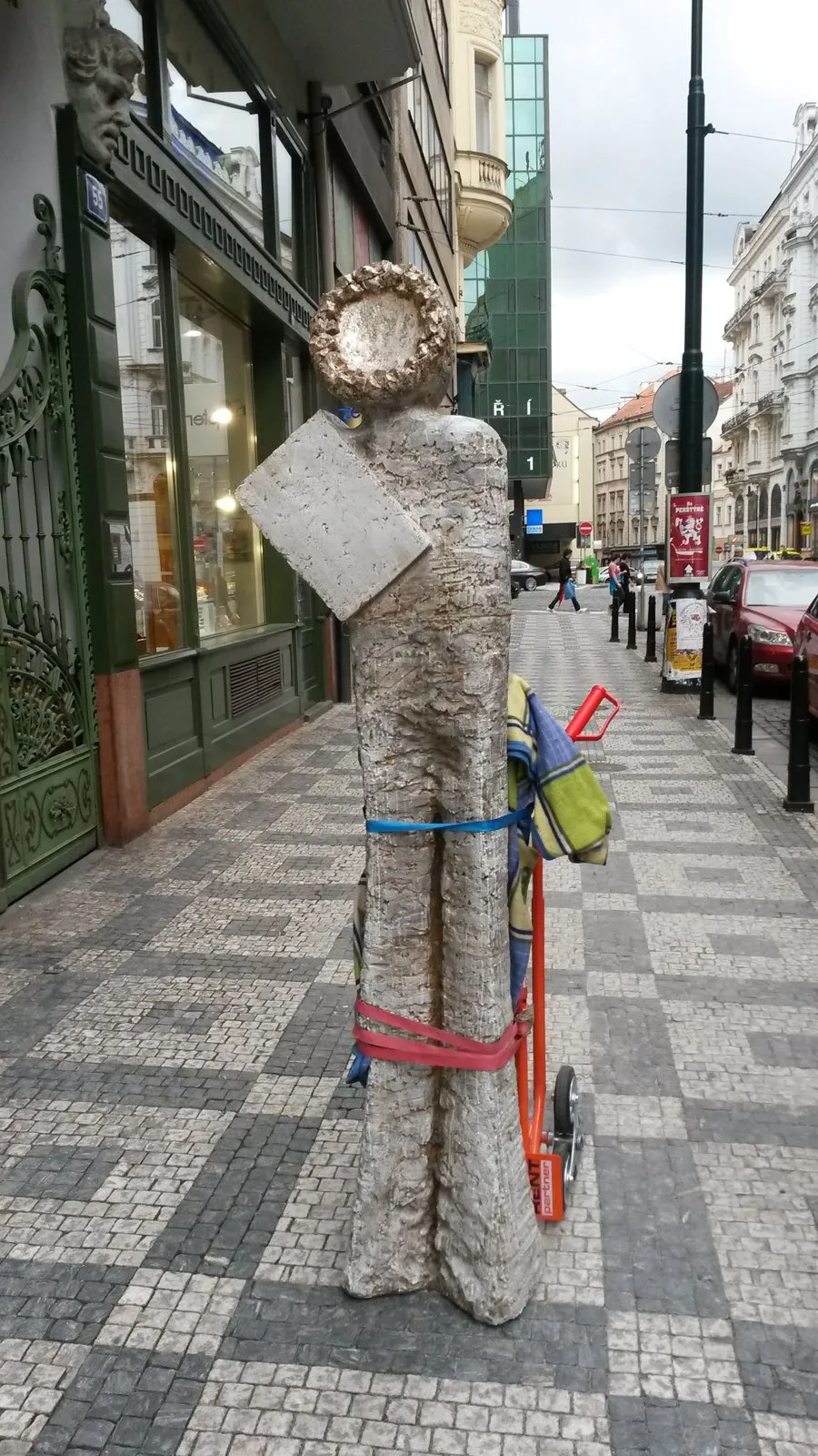 Plastika Prorok I na dlážděném chodníku v ulici